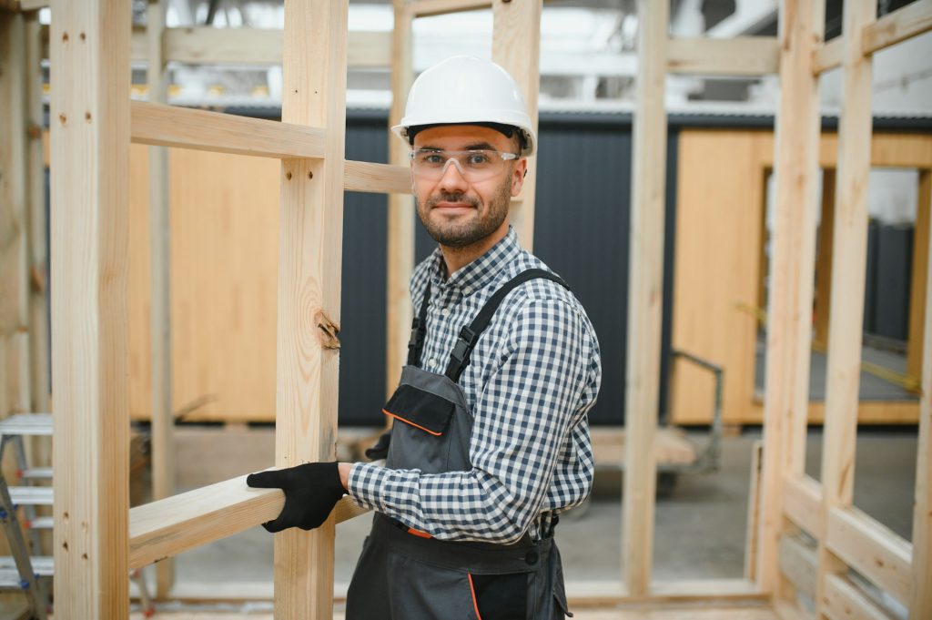 Worker carpenter assembling a modular house